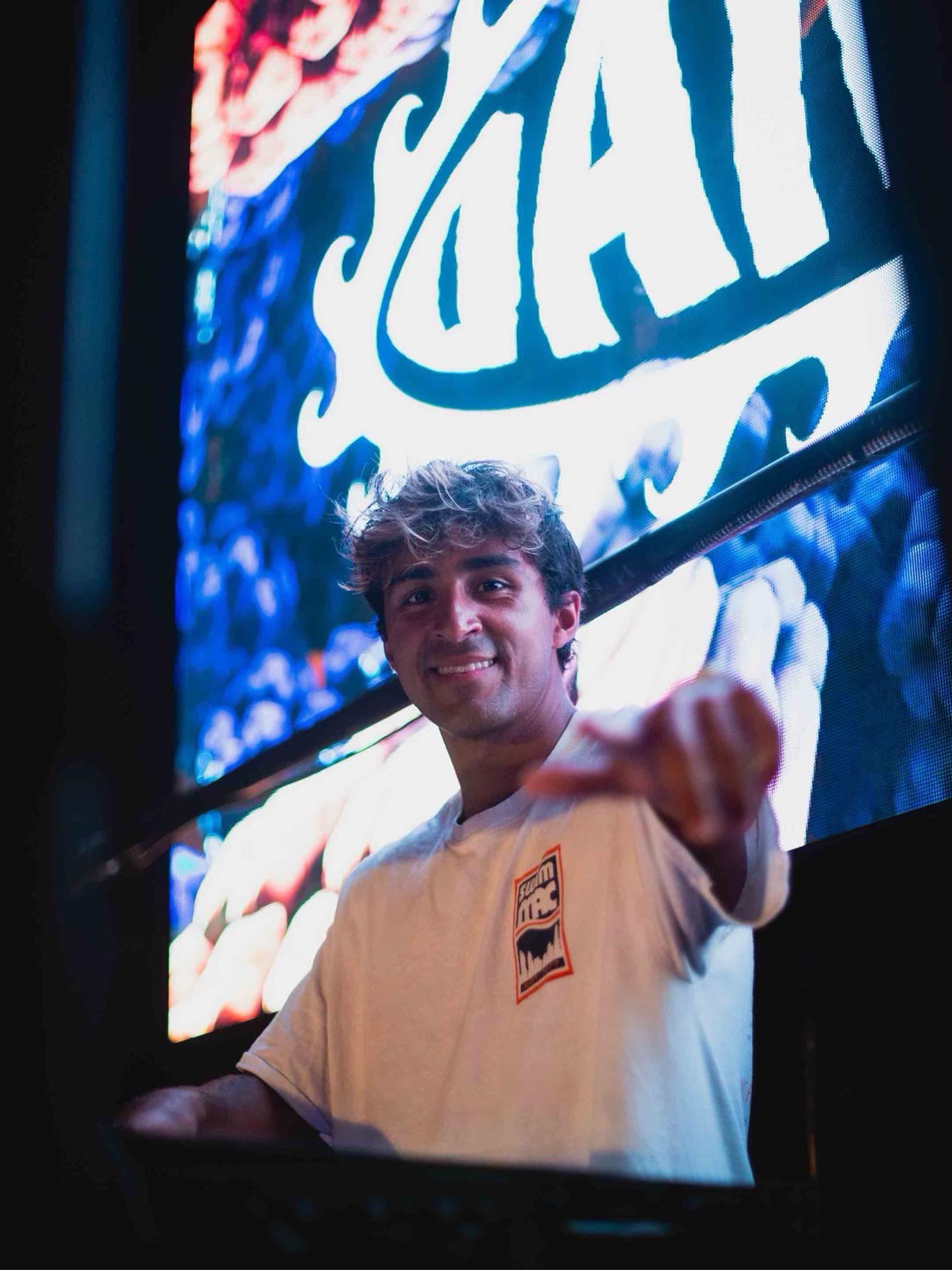 DJ Danny with logo in background on large screen on DJ stage